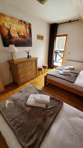 a bedroom with two beds and a dresser at Osada Kuboski Dom z Bali Leśny Zakątek in Kamesznica