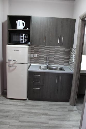 a kitchen with a white refrigerator and a sink at Vot villas in Ormos Panagias