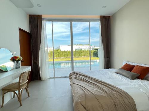 a bedroom with a bed and a desk and a window at Dani Villa- Spacious Private pool villa 4 Bed 4 bath in Khao Tao
