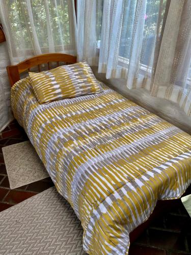 a bed sitting in a room with a window at Casa Magnolia in Cumbayá