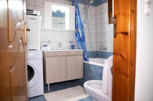a bathroom with a washing machine and a washer at Zorbas House in Heraklio
