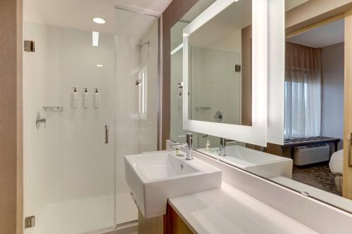 a white bathroom with a sink and a shower at SpringHill Suites by Marriott Cheraw in Cheraw