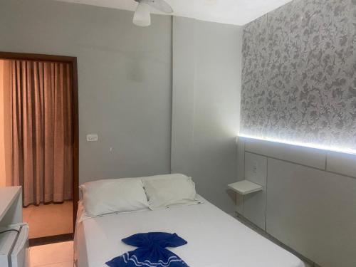 a small bedroom with a bed with a blue bow on it at El Nassr suits in Goiânia
