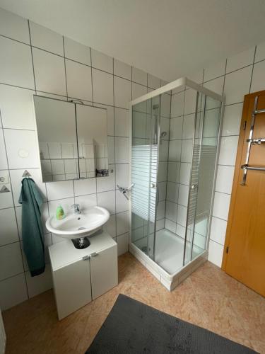 a bathroom with a glass shower and a sink at Ferienwohnung Fam. Albert in Heuchelheim-Klingen