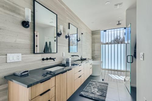 a bathroom with two sinks and a large mirror at Modern House Downtown View with Pool & Hot Tub in Austin