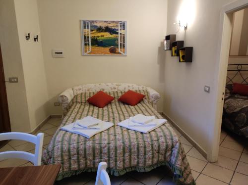 a small bedroom with a bed with two napkins on it at La piccola Posta di Cortona in Cortona