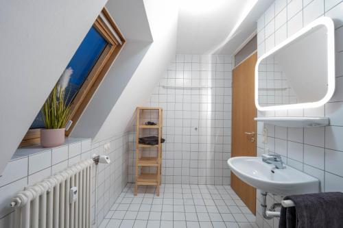 a white bathroom with a sink and a window at Loft mit Balkon im Historischen Altbau am Marktplatz - 75qm, DisneyPlus, 300mbs Internet in Chemnitz