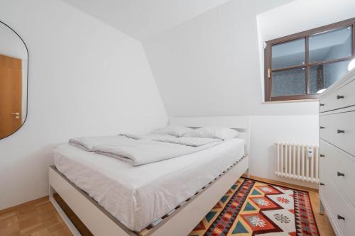a white bedroom with a bed and a window at Loft mit Balkon im Historischen Altbau am Marktplatz - 75qm, DisneyPlus, 300mbs Internet in Chemnitz