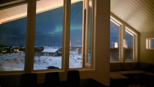 a room with windows with a view of a snow covered yard at Torghatten bnb in Brønnøysund