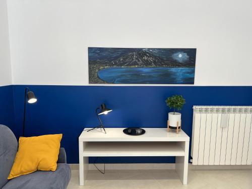 a living room with a white table and a blue wall at Duomo Inn Apartments in Naples