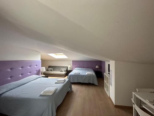 - 2 lits dans une chambre avec tête de lit violette dans l'établissement Hotel Irene, à Lignano Sabbiadoro