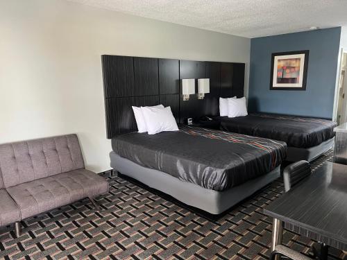 um quarto de hotel com uma cama e um sofá em Executive Inn em Pelham