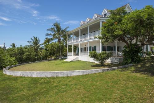 une grande maison blanche avec une grande cour dans l'établissement Buccaneer Hill Main House home, à Governorʼs Harbour