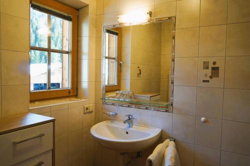 ein Bad mit einem Waschbecken und einem Spiegel in der Unterkunft Lederer Zuhaus in Alpbach