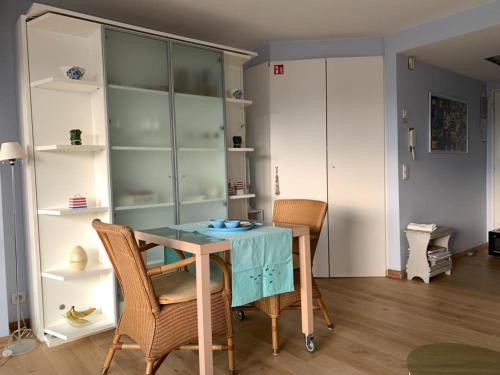 a dining room with a blue table and chairs at Sunny studio with seaview in Knokke-Heist