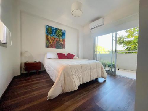a bedroom with a bed and a painting on the wall at Departamento Moderno La Plata, Plaza España in La Plata