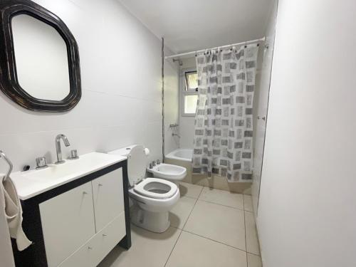 a bathroom with a toilet and a sink and a mirror at Departamento Moderno La Plata, Plaza España in La Plata