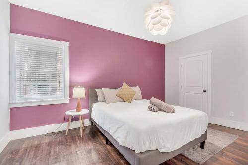 a bedroom with a purple accent wall and a bed at Stunning Old City 2 Bedroom - Elevator, Bay Windows in Philadelphia
