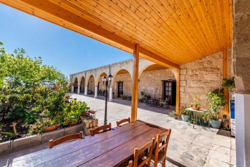 une terrasse avec une table et des bancs en bois dans l'établissement Revaklı Ev Guest House, à Rizokarpaso