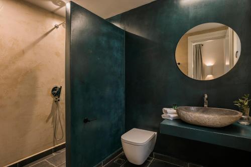 a bathroom with a sink and a toilet and a mirror at FRG Villas - Villa Volare in Kefallonia