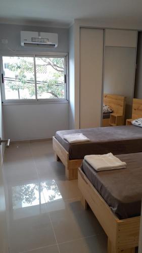 1 dormitorio con 2 camas y ventana en Departamento 2 ambientes, hermoso y muy comodo. en Santiago del Estero