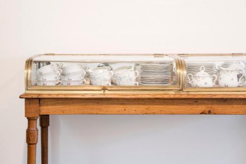 a glass shelf with dishes and plates on a table at Loweide Lodges & Holiday Homes near Bruges in Oostkamp