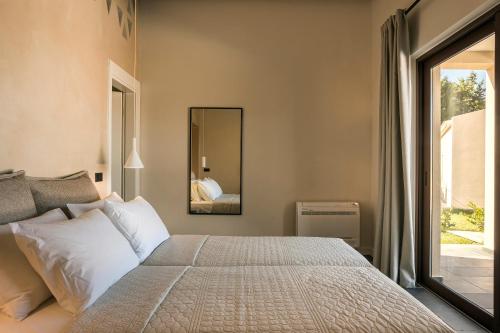 a bedroom with a large bed and a mirror at FRG Villas - Villa Volare in Kefallonia