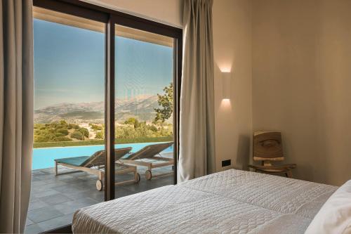 a bedroom with a bed and a view of a pool at FRG Villas - Villa Volare in Kefallonia