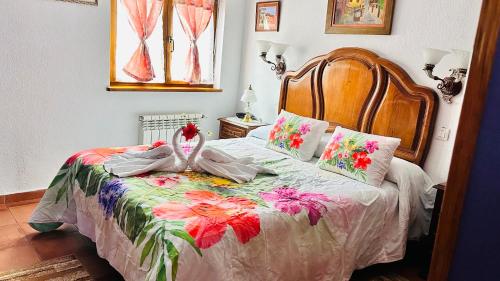 Dormitorio con cama con manta estampada de flores en La torrevia, en Santillana del Mar