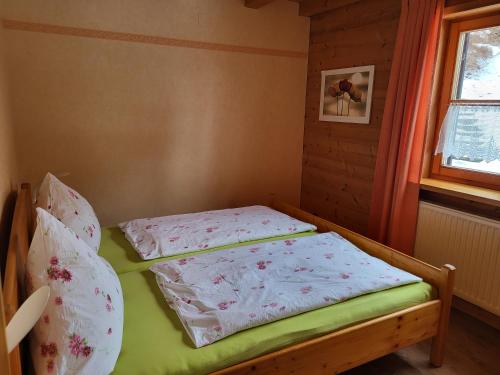 Am Sonnenhang في ايمنستادت ام الغو: غرفة نوم صغيرة مع سرير بملاءات وردية وبيضاء