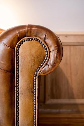 a brown leather chair with ainylinylinylinylinylinylinylinylinylinyl at Loweide Lodges & Holiday Homes near Bruges in Oostkamp