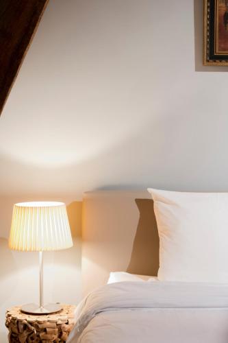 a bedroom with a bed and a table with a lamp at Loweide Lodges & Holiday Homes near Bruges in Oostkamp