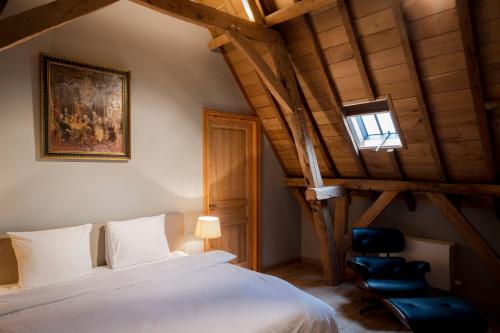 1 dormitorio con 1 cama blanca y 1 silla negra en Loweide Lodges & Holiday Homes near Bruges en Oostkamp