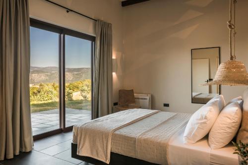 sypialnia z łóżkiem i dużym oknem w obiekcie FRG Villas - Villa Cantare w mieście Kefalonia