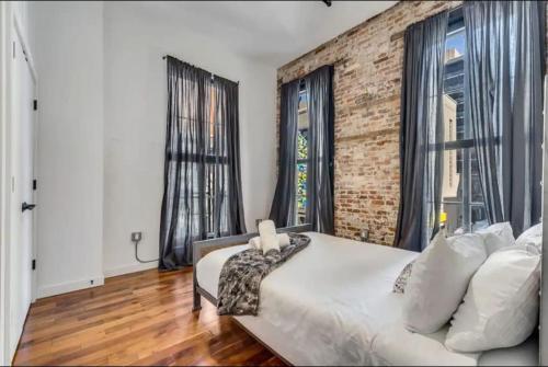 1 dormitorio con cama blanca y pared de ladrillo en 30 S 7th St Unit 3 LUXURIOUS Million Dollar Condo Elevator Parking Location, en Filadelfia