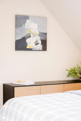 a bedroom with a bed and a painting on the wall at Loweide Lodges & Holiday Homes near Bruges in Oostkamp