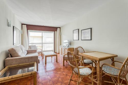 ein Wohnzimmer mit einem Sofa, einem Tisch und Stühlen in der Unterkunft Apartamentos Granxola in Sanxenxo
