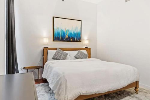 a bedroom with a white bed with a wooden frame at The Founders Suite Residence in Philadelphia