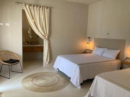een slaapkamer met 2 bedden, een spiegel en een tapijt bij The Mantarraya Outpost in La Paz
