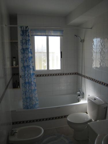 baño con bañera, aseo y ventana en Casa Yvonne, en Rojales