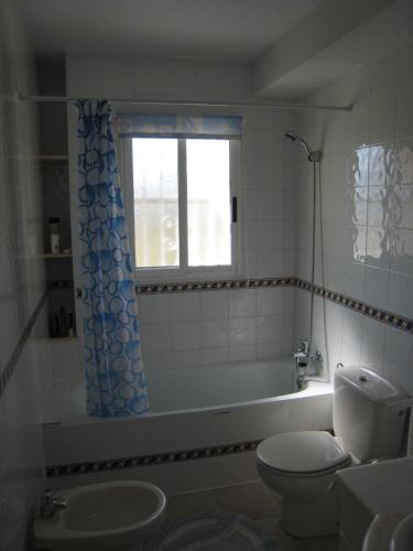 a bathroom with a tub and a toilet and a window at Casa Yvonne in Rojales