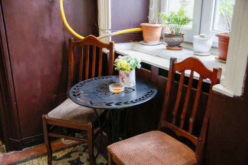 un tavolino con fiori accanto a due sedie di Apartment on Chubinashvili 30 a Tbilisi City
