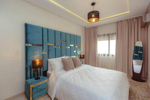 sypialnia z dużym łóżkiem z niebieskim zagłówkiem w obiekcie Cozy 2-bedroom apartment in Gueliz, Marrakech w Marakeszu