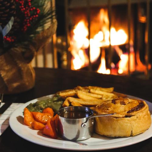 a plate of food with a sandwich and french fries at The Peacock at Barlow in Chesterfield