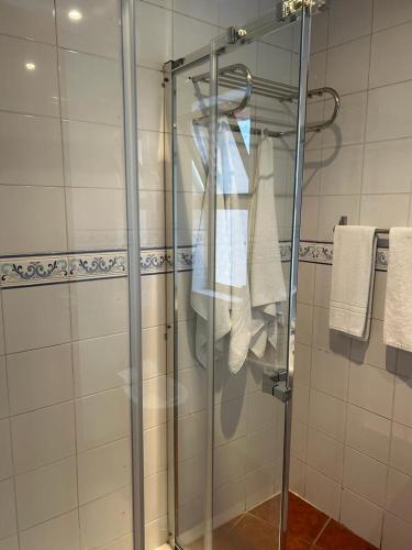 a glass shower in a bathroom with towels at Copacabana Residencial in Costa da Caparica