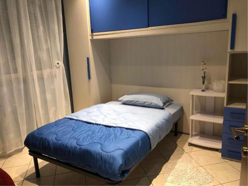 a bedroom with a bed with a blue comforter at CASA ORCHIDEA in Fiumicino