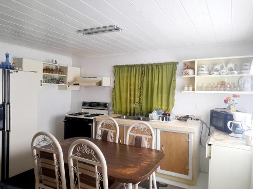 uma cozinha com uma mesa de madeira, uma mesa e cadeiras em Casa de hospedaje em Ciudad Juárez