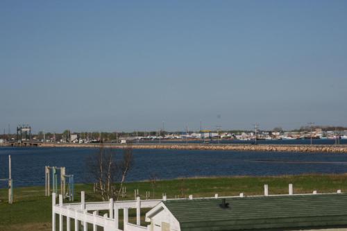 a white fence next to a body of water at Escale de l'île - Auberge Janine du Havre in Shippagan