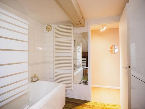 uma casa de banho com uma banheira e um espelho. em Le Cézanne - Jardin - Parking - Babyfoot - Centre-ville em Troyes