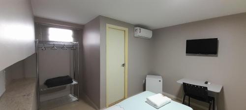 a small room with a bed and a television at Pousada Kit Residence in Brasilia